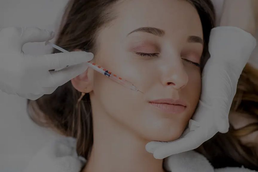 A smiling woman enjoying an expert massage service at Hand & Stone Massage and Facial Spa.